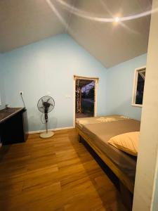 um quarto com uma cama e uma ventoinha. em Tetaha Lodge em Tiputa