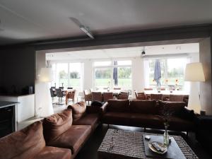 TeugeにあるVilla near Teuge Airport and Paleis 't Looのリビングルーム(ブラウンソファ、テーブル付)