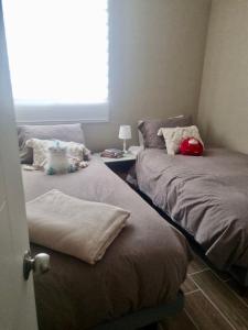 two beds in a room with a window at Martin Pescador in Puerto Montt