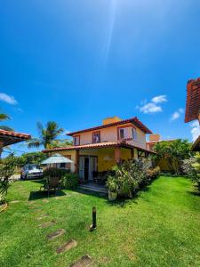 a house with a green yard with a grass yard at Paraíso dos Corais - Casa 40 in Paripueira