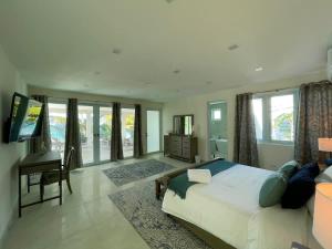 a bedroom with a bed and a desk and windows at Beachfront Spacious Luxury Villa Private Pool in Fortuna