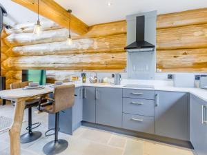 a kitchen with blue cabinets and a wooden wall at Hope Hideaway 