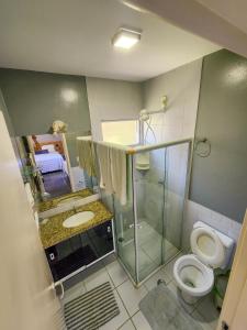 a bathroom with a toilet and a shower and a sink at Paraíso dos Corais - Casa 40 in Paripueira +27 photos