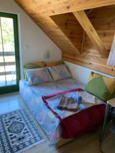 een bed in een kamer met een houten plafond bij Apartments Durmitor in Žabljak