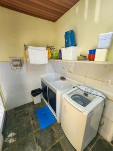 a small kitchen with a washing machine in it at Paraíso dos Corais - Casa 40 in Paripueira