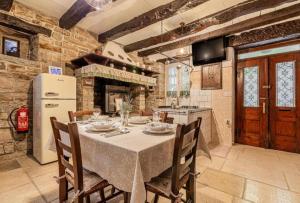 een keuken met een tafel met stoelen en een koelkast bij Villa Nostalgia pool & wellness in Gračišče