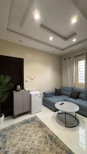 a living room with a blue couch and a table at شقة غرفة نوم وصالة in Jazan +1 photo