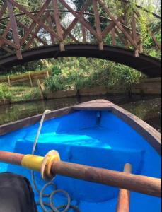 a blue boat in the water under a bridge at Charming Country Retreat -Lake View Cottage with Hot tub in Wisbech Saint Mary