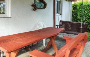 a wooden picnic table with two chairs and a bench at 4 Bedroom Amazing Home In Parzensko in Nowogródek Pomorski +9 photos