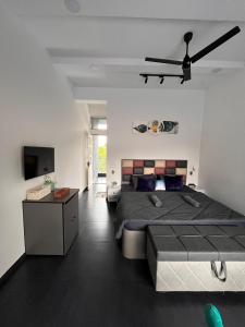 a bedroom with a large bed and a ceiling fan at Casa Oceanus - 3 Bedroom - Sea Facing Pool Villa - Ganpatipule in Ganpatipule +75 photos