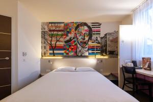 a bedroom with a bed and a painting on the wall at B&B Hotel Łódź Centrum in Łódź