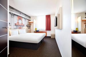 a hotel room with two beds and a tv at B&B Hotel Łódź Centrum in Łódź