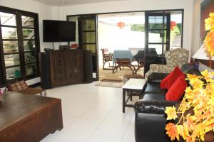 a living room with a couch and a tv at Phuket Gay Homestay in Kathu