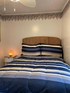 a bedroom with a bed with blue and white stripes at The Lily Pad in Pinckney