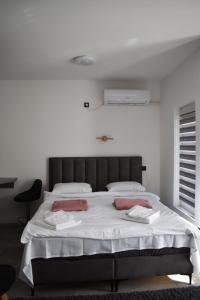 a bedroom with a large bed with white sheets at Apartman Palermo in Višegrad