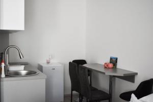 a kitchen with a sink and a table with chairs at Apartman Palermo in Višegrad +27 photos