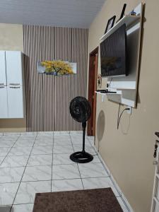 a room with a fan in the corner of a kitchen at KL Residencial in Manaus