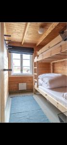 a bedroom with two bunk beds and a window at Stinebua in Vestvågøya