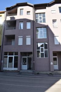 an apartment building with white windows on a street at Apartman Palermo in Višegrad