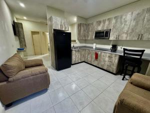a kitchen with a couch and a refrigerator in a room at Mini Suits Limpias y Confortables in Villa de Ojinaga