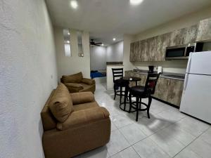 a living room with a couch and a kitchen at Mini Suits Limpias y Confortables in Villa de Ojinaga