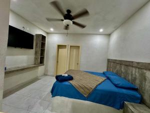 a bedroom with a bed with a ceiling fan at Mini Suits Limpias y Confortables in Villa de Ojinaga