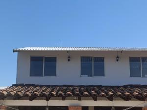 a white building with windows and a roof at Hospedaje alcatraz in Chignahuapan