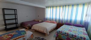 a small bedroom with two beds and a window at Hospedaje alcatraz in Chignahuapan