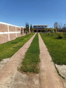 a dirt road in a field with a building in the background at Hospedaje alcatraz in Chignahuapan
