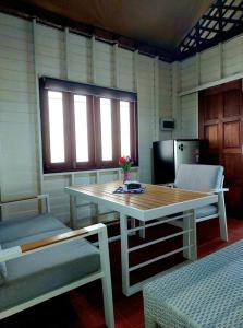 a room with a table and a table and a chair at Wooden House On The Bay in Ban Bang Chak