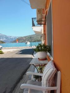 a table with a potted plant on the side of a building at Afroessa Apartment Ithaca ΙΙ in Vathi, Ithaka