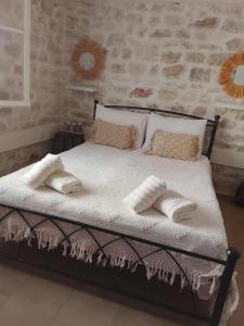 a bed with white sheets and pillows in a bedroom at Afroessa Apartment Ithaca ΙΙ in Vathi, Ithaka