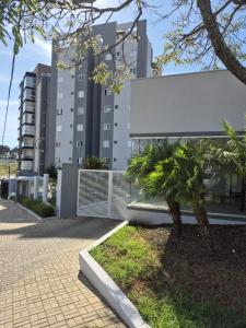 ein Gebäude mit einer Palme davor in der Unterkunft Apartamento Tennis Prime in Oliveira