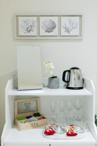 a white shelf with a tea kettle and dishes on it at Mudeford Beach Guest Room in Mudeford