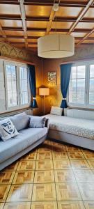 a living room with a couch and two windows at Casa Jenini - Wohnung im Patrizierhaus neben Schloss Leuk in Leuk