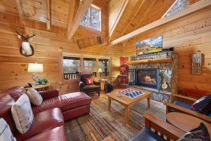 a living room with a fireplace in a log cabin at Sugars Cozy Cabin in Sugar Mountain