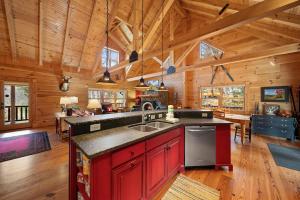 a kitchen and living room of a log cabin at Sugars Cozy Cabin in Sugar Mountain +18 photos