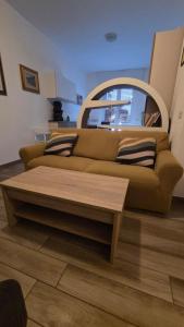 a brown couch in a room with a table at Rocca view central flat in Arona +1 photo