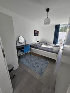 a bedroom with a bed and a desk and a chair at UZ Villa 11 - Modern Living Laatzen in Hannover