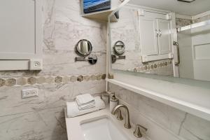 a bathroom with a sink and a toilet and a mirror at Easy Cleveland Access! Quiet Suburb Stay with Yard in Oakwood +20 photos