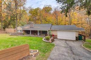 a small house with a garage in a yard at Easy Cleveland Access! Quiet Suburb Stay with Yard in Oakwood