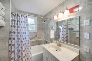 a bathroom with a sink and a shower curtain at Central Akron Stay! Large Victorian Home with Yard in Akron +18 photos