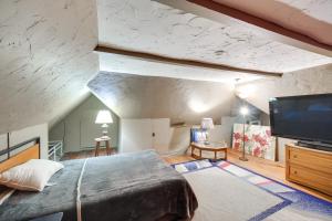 a bedroom with a large bed and a flat screen tv at Central Akron Stay! Large Victorian Home with Yard in Akron