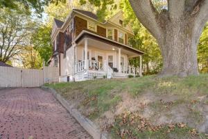 a house on a hill with a tree at Central Akron Stay! Large Victorian Home with Yard in Akron