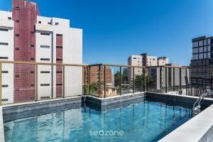 a swimming pool on the roof of a building with buildings at Sua estadia a 350m da Praia em prédio c/ piscina na melhor localização de Cabedelo-PB | PTAs in Ilha da Restinga