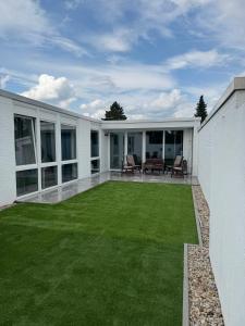 a large patio with a yard of green grass at UZ Villa 11 - Modern Living Laatzen in Hannover +19 photos