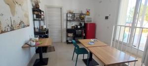 a room with two wooden tables and a red refrigerator at L'Arco sul Mare in Porto Cesareo