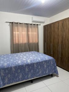 a bedroom with a bed and wooden cabinets at Ninho dos falcões in Nobres