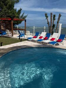 Una piscina con tumbonas y el océano. en Beachfront Spacious Home Private Luxury Pool, en Las Coles 61 fotos más