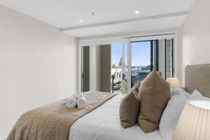 a bedroom with a bed with a large window at Spacious apartment in Mount Maunganui in Mount Maunganui